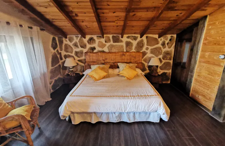 dormitorio con su techo de madera