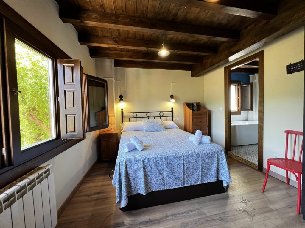 dormitorio con techo de vigas en casa rural en asturias